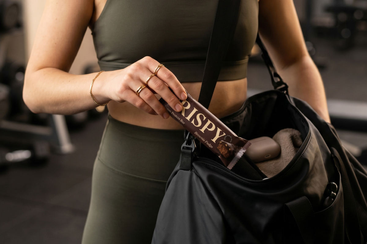 Sportliche Frau holt Vetains Crispy Proteinriegel aus ihrer Tasche