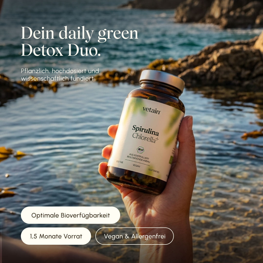 Hand hält eine Flasche Vetain Spirulina Chlorella+ Bio-Tabletten vor einem felsigen Küstenpanorama mit Meerwasser im Hintergrund. Text: „Dein daily green Detox Duo – pflanzlich, hochdosiert und wissenschaftlich fundiert." Badges: Optimale Bioverfügbarkeit, 1,5 Monate Vorrat, Vegan & Allergenfrei.