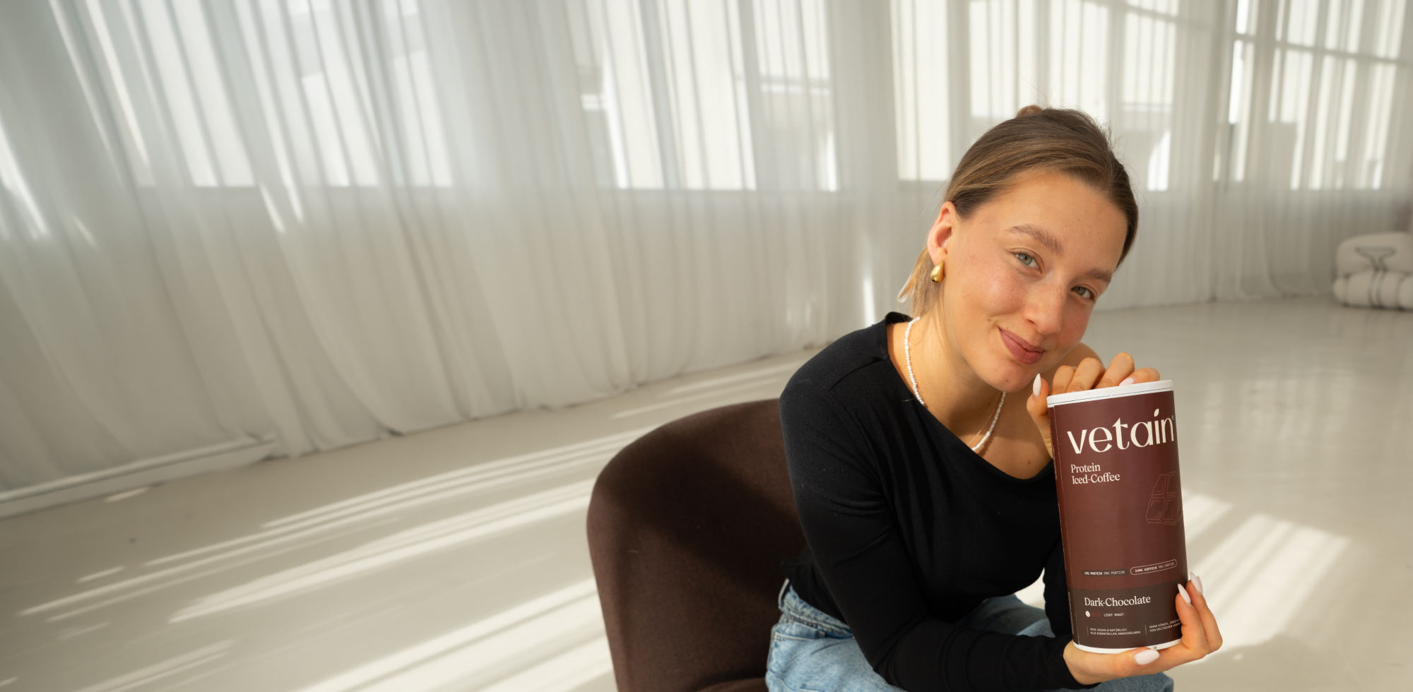 Maria Maas hält eine Dose des Vegan Protein Iced-Coffee von Vetain 