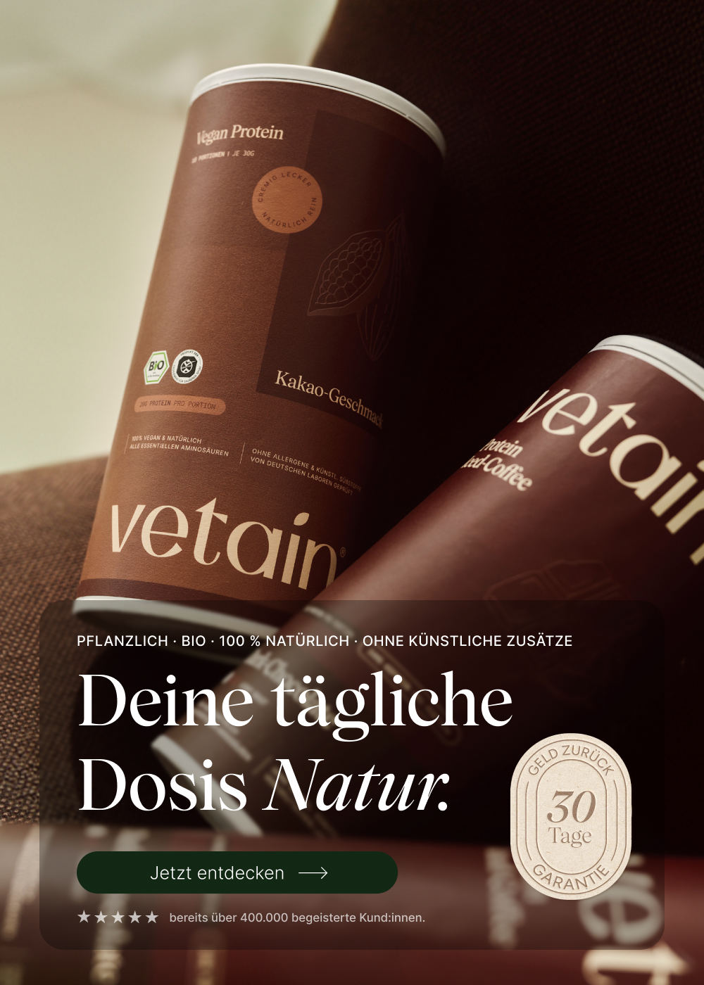 Vetain Vegan Protein Hero-Banner (Hochformat) mit zwei Dosen (Kakao und Iced-Coffee). Headline „Deine tägliche Dosis Natur." mit Button „Jetzt entdecken" und 30-Tage-Geld-zurück-Siegel.