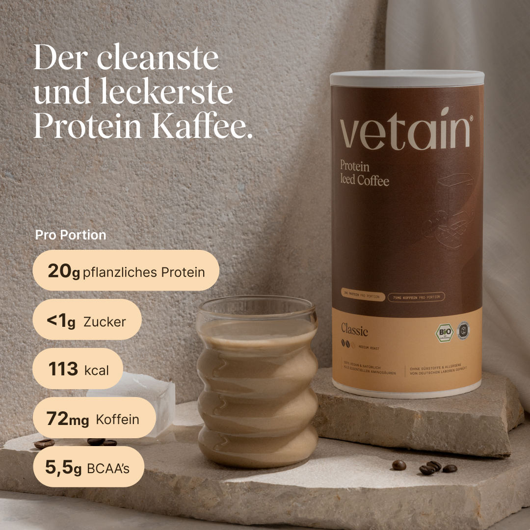 Vetain Protein Iced Coffee Classic (Bio) neben einem Glas kaltem Protein-Kaffee auf Steinpodest mit Kaffeebohnen. Text: „Der cleanste und leckerste Protein Kaffee.“ Nährwerte pro Portion: 20g pflanzliches Protein, <1g Zucker, 113 kcal, 72mg Koffein, 5,5g BCAAs.