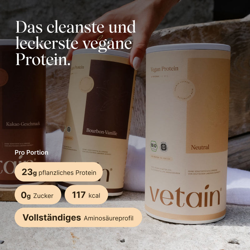 Drei Dosen vetain Vegan Protein nebeneinander auf einer Steinfläche, im Vordergrund die Sorte Neutral, dahinter Bourbon-Vanille und Kakao-Geschmack. Überschrift: ‚Das cleanste und leckerste vegane Protein.' Angaben pro Portion: 23 g pflanzliches Protein, 0 g Zucker, 117 kcal, vollständiges Aminosäureprofil.