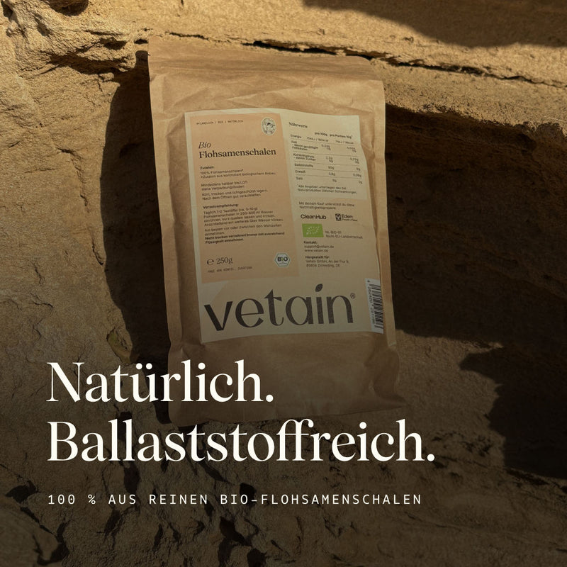 Vetain Bio Flohsamenschalen im Papierbeutel (250 g) auf hellem Sandstein in der Sonne. Textüberlagerung „Natürlich. Ballaststoffreich." und „100 % aus reinen Bio-Flohsamenschalen".