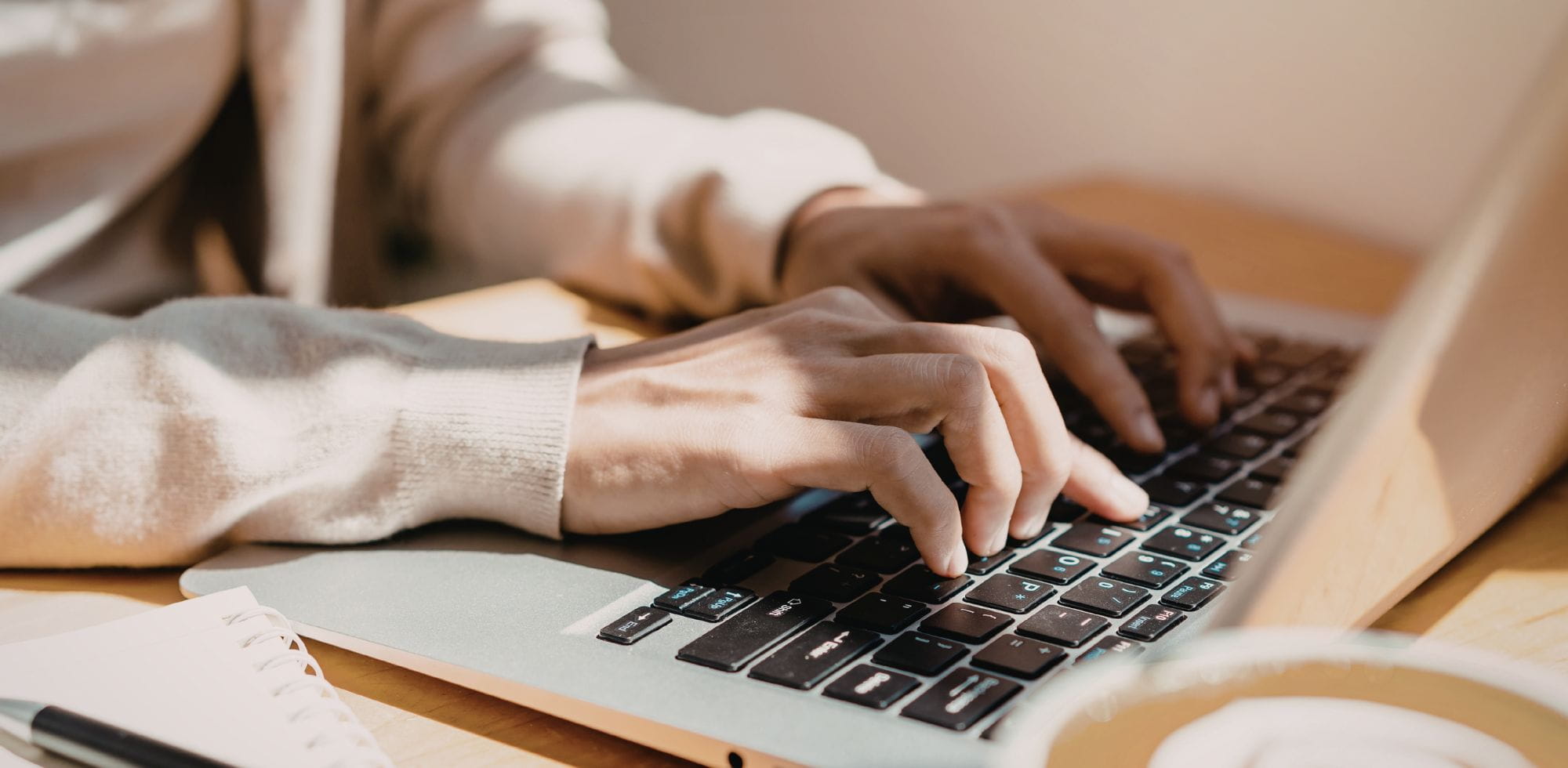 Weibliche Hand schreibt auf einem Laptop